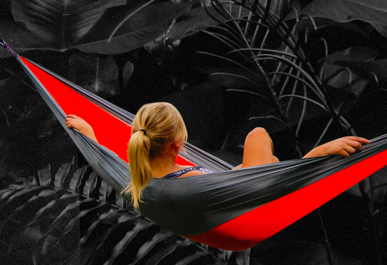 Woman enjoying a relaxing hammock over a dark colorless jungle background photo