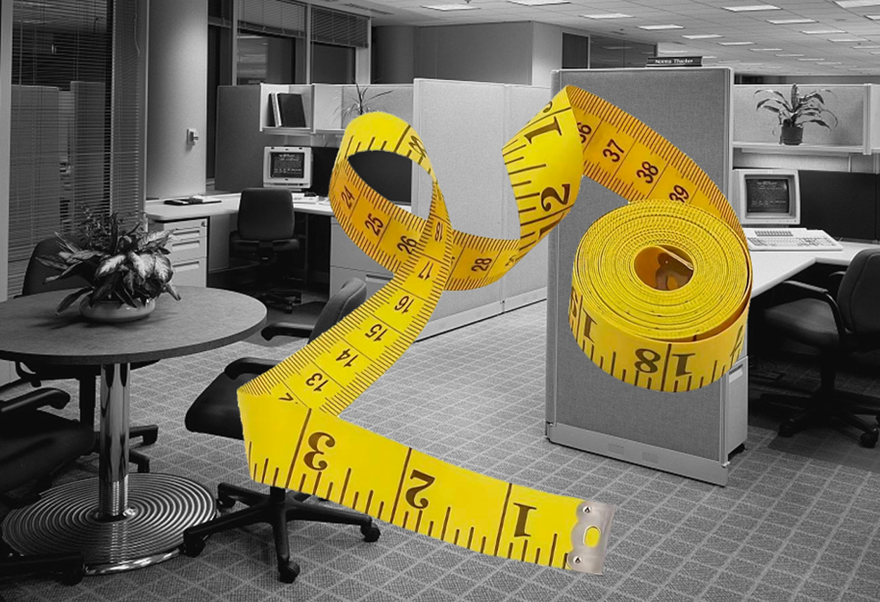 Retro cubicles and chairs in an office that looks like it's from the 1980s with a cutout yellow measuring tape over the photo