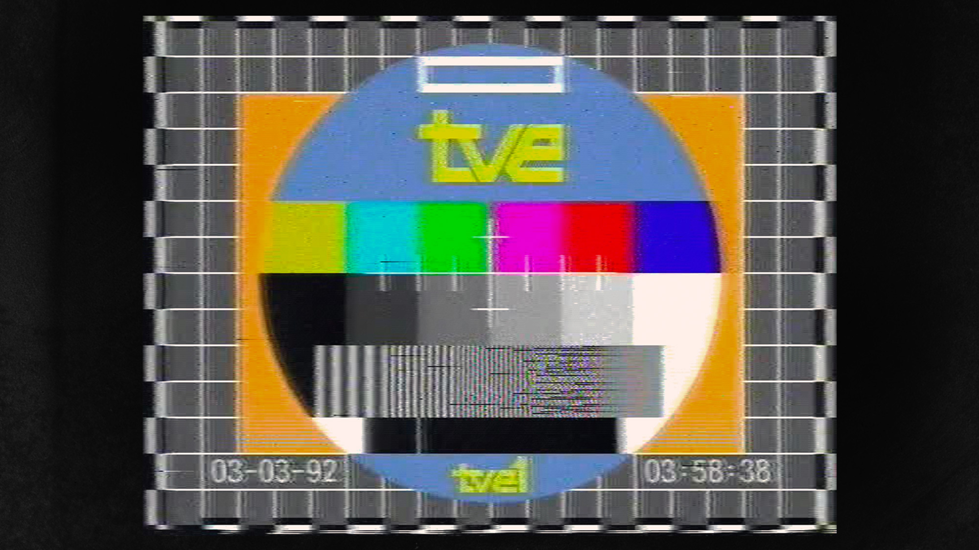 Off-air recording of TVE 1 version (1990–93 version, on 3 March 1992) - a circular blue pattern on gray grid background, orange square, rainbow squares, the letters tve in yellow